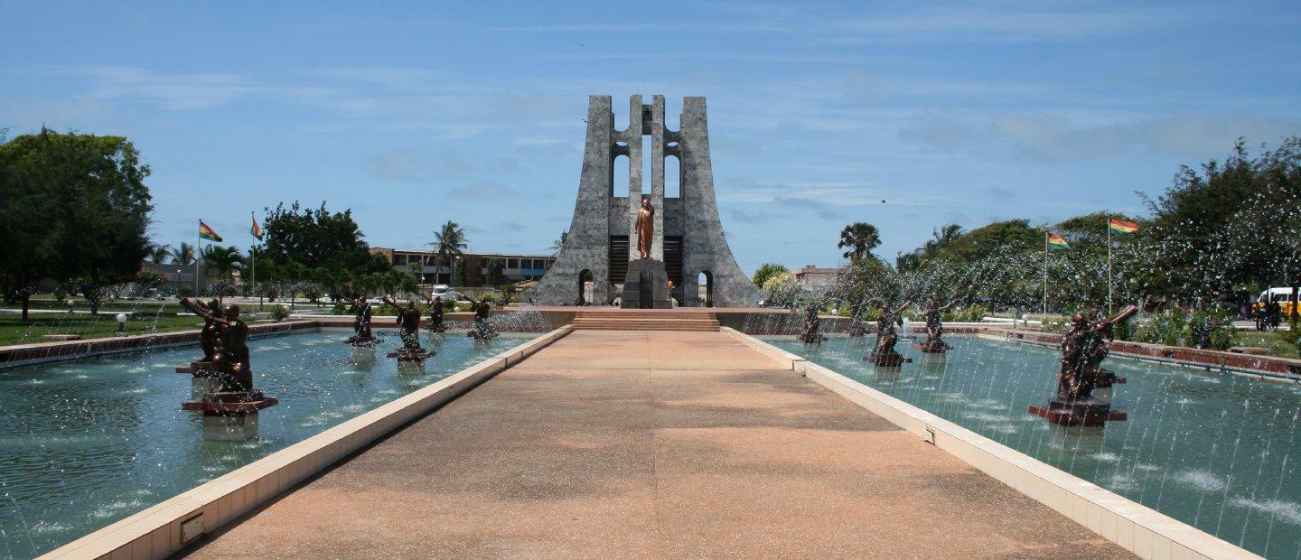A fountain in Ghana with sculptures and a path in the middle.