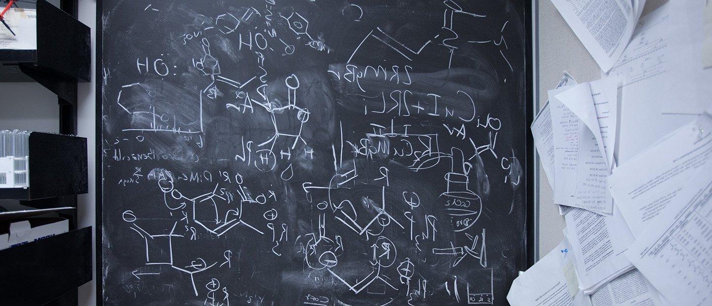 黑板上写着化学方程式和图表.
